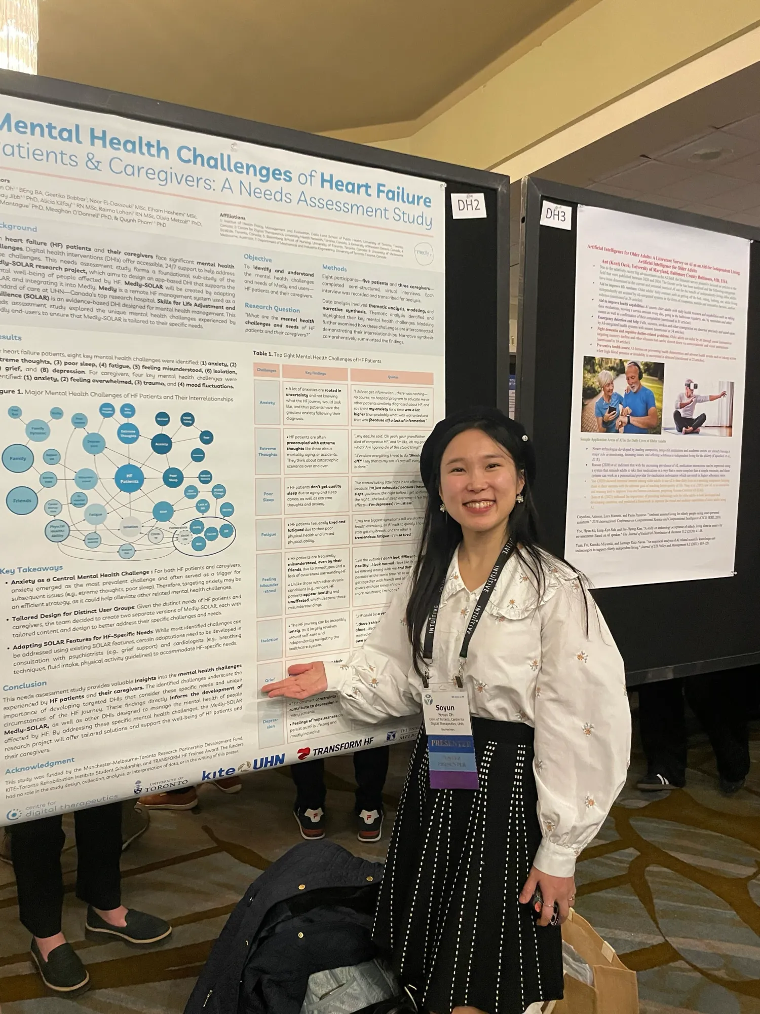 A person in a black beret smiling and pointing to a research poster about mental health challenges of heart failure patients and caregivers